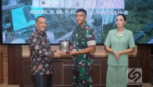 Asisten Pemerintahan dan Kesejahteraan Rakyat Pemkab Asahan saat menyerahkan plakat kepada Danrem 022 Pantai Timur, Kolonel Inf Agustatius Sitepu